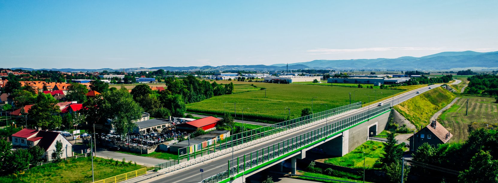 Wiadukt drogowy widziany z góry, w tle góry i miasto