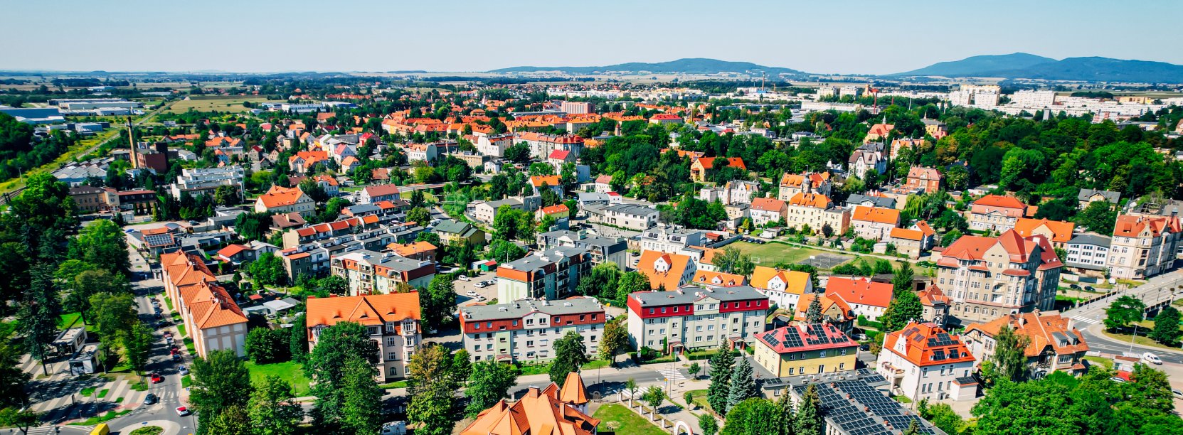 Panorama miasta na tle gór, dużo zieleni