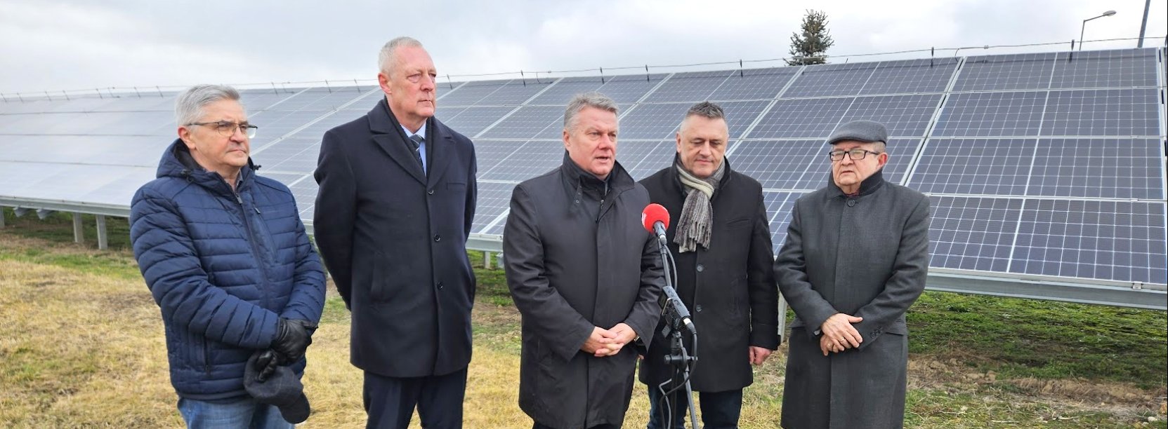 Na tle palneli fotowoltaicznych stoją od lewej: Krzysztof Galiak – przewodniczący Rady Nadzorczej Energia Komunalna Sp. z o.o, Marek Chmielewski – poseł na Sejm RP, Dariusz Kucharski – burmistrz Dzierżoniowa,  Tomasz Smolarz – prezes Zarządu Energia Komunalna Sp. z o.o., Andrzej Bronowicki, prezes spółki Wodociagi i Kanalizacja w Dzierżoniowie.