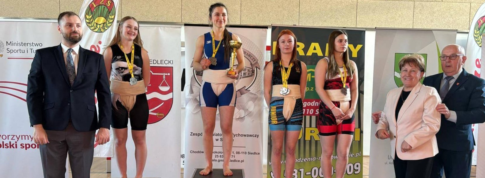 Cztery zawodniczki na podium z pucharami i dyplomami