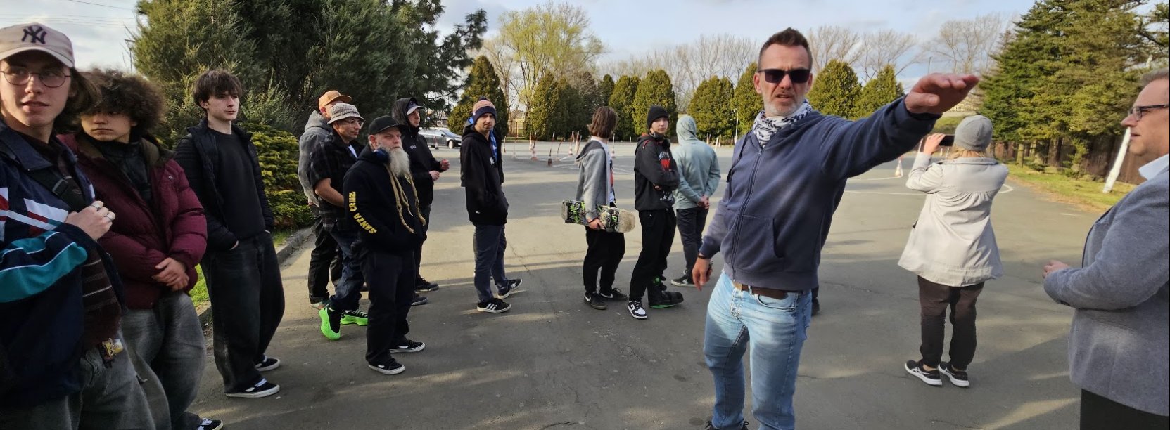 Grupa osób stojąca na asfaltowym placu przed Ośrodkiem Sportu i Rekreacji w Dzierżoniowie
