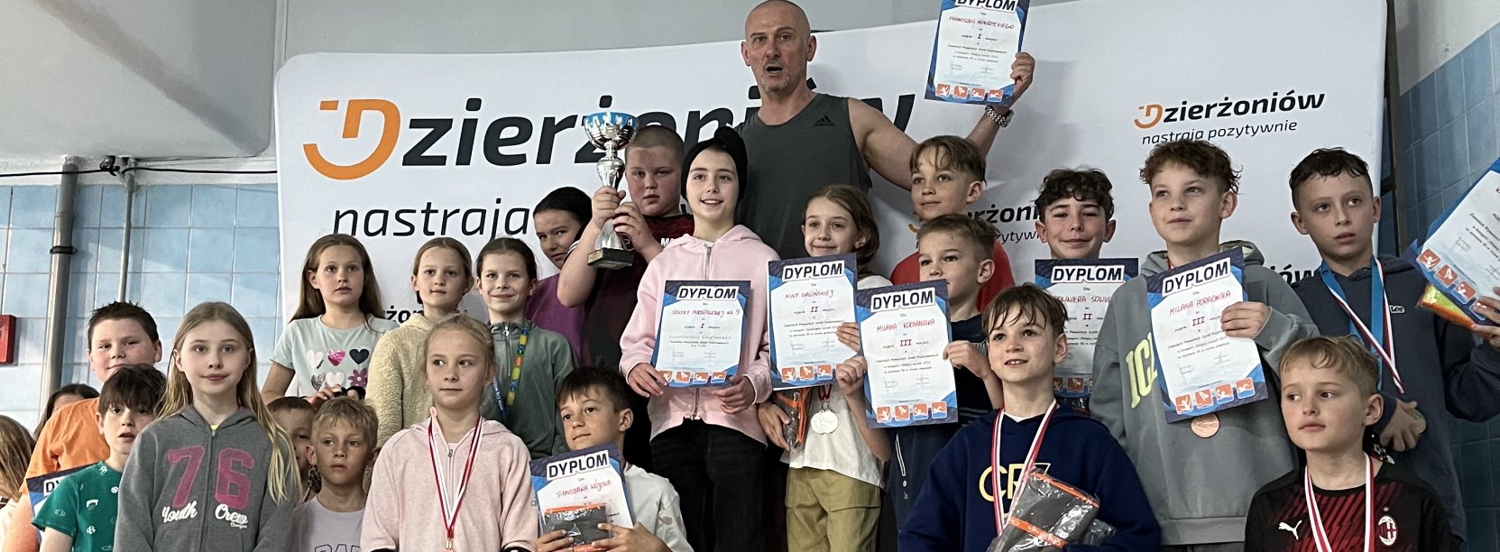 Grupa dzieci z dyplomami i medalami 