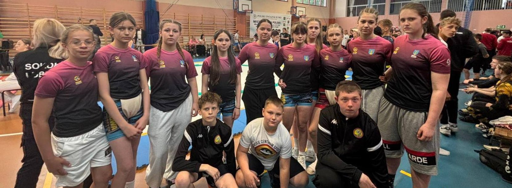 Zawodniczki i zawodnicy klubu Junior Dzierżoniów na wspólnym zdjęciu w hali sportowej