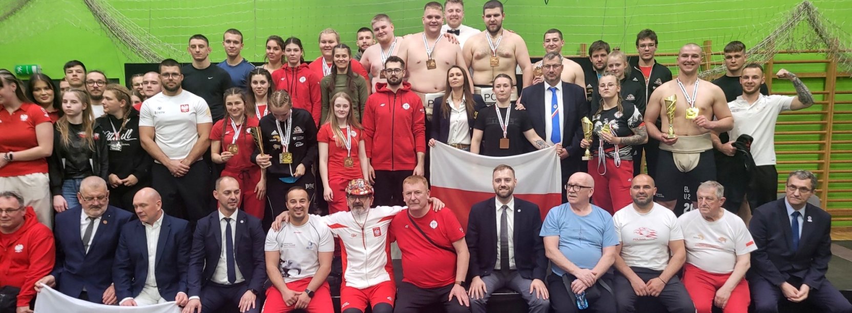 Grupowe zdjecie zawodnków, trenerów i działaczy, wielu z nich z barwach Polski