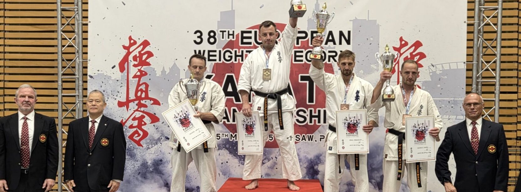 Tomasz Staściuk na najwyższym stopniu podium z uniesionym do góry pucharem