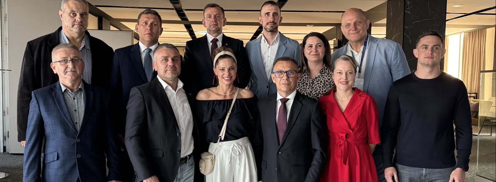 Dwunastu członków zarządu Polskiego Związku Zapaśniczego na wspólnym zdjęciu. Alicja Dydo-Warchoł w czerwonej sukience