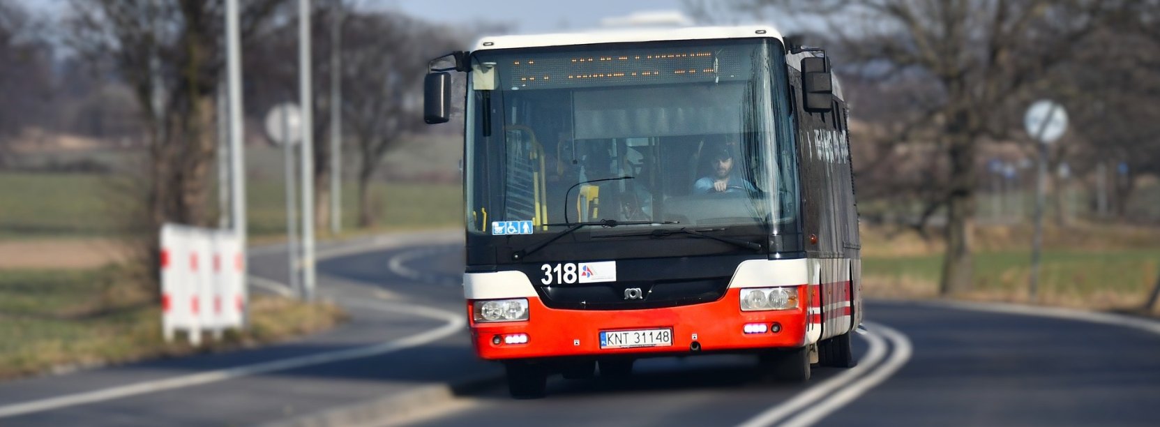 Jadący drogą pomiędzy miastami autobus komunikacji miejskiej od przodu