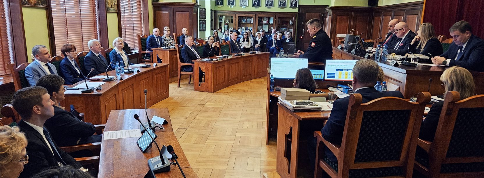 Sala Rycerska podcza sesji, radni siedzący przy stołach, po prawej stół prezydialny, w drugim planie widownia