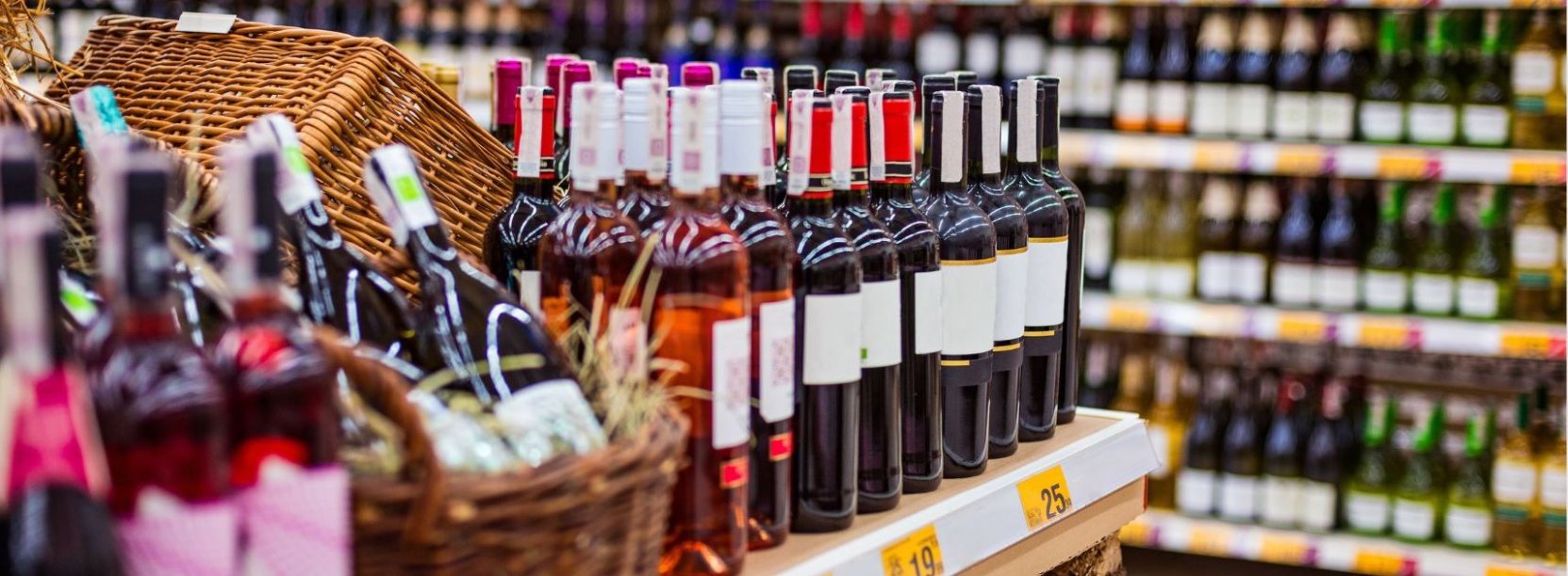 sklep z alkoholem, na półkach stoją rzędy butelek w różnych kolorach
