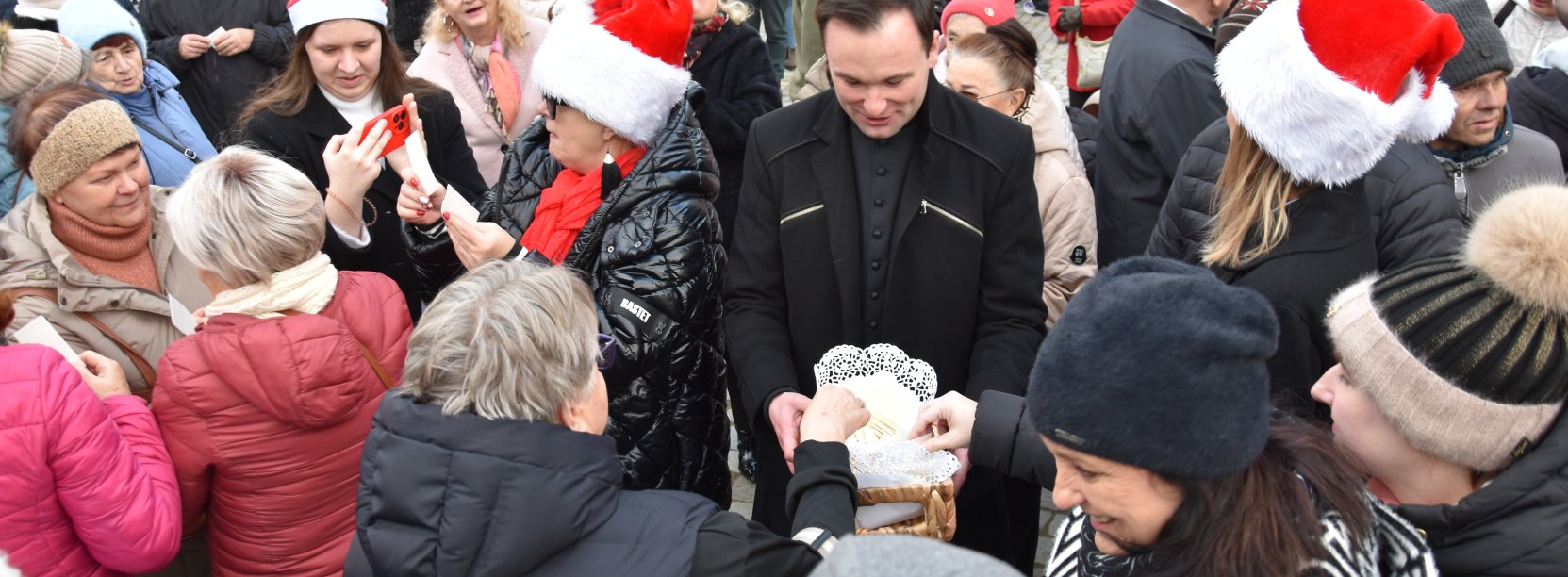 Wigilia miejska, ludzie dzielący się opłatkiem