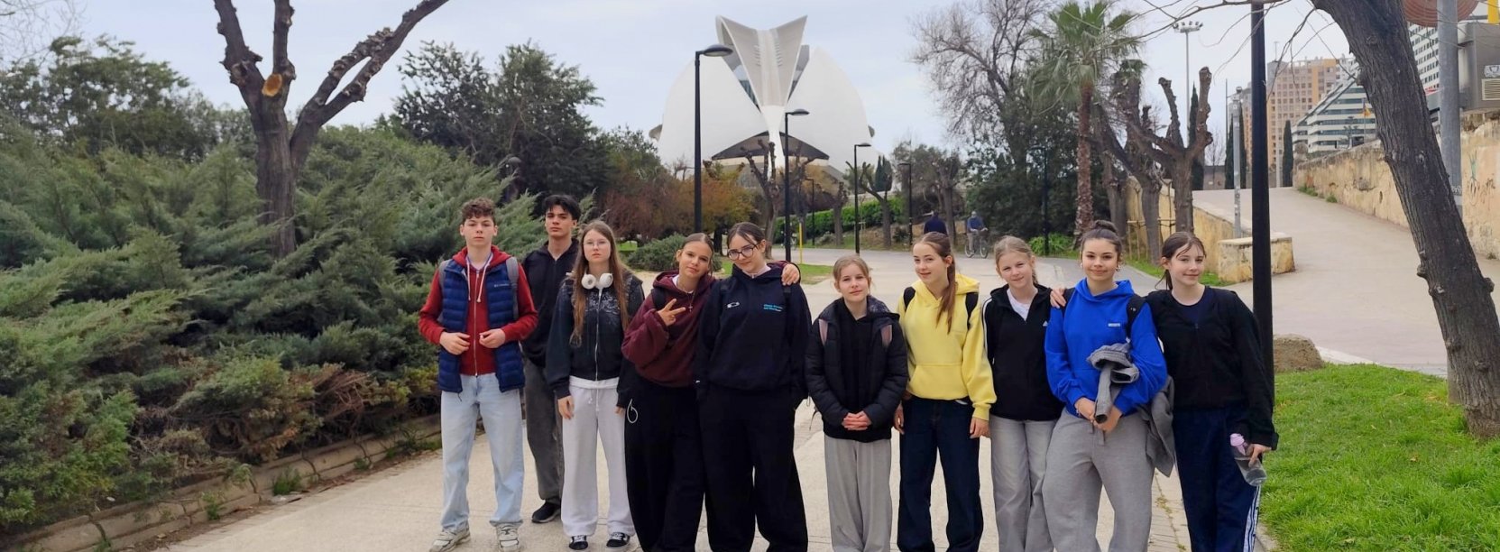 10 uczniów SP 9 na deptaku, w tle futurystyczny budynek