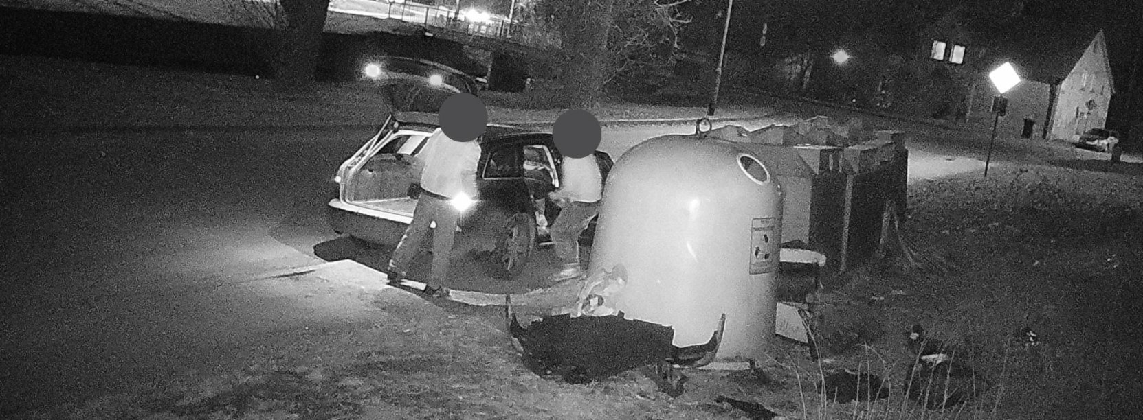 czarno-białe zdjęcie z fotopułapki, przedstawiające mężczyzn nielegalnie wyrzucających odpady
