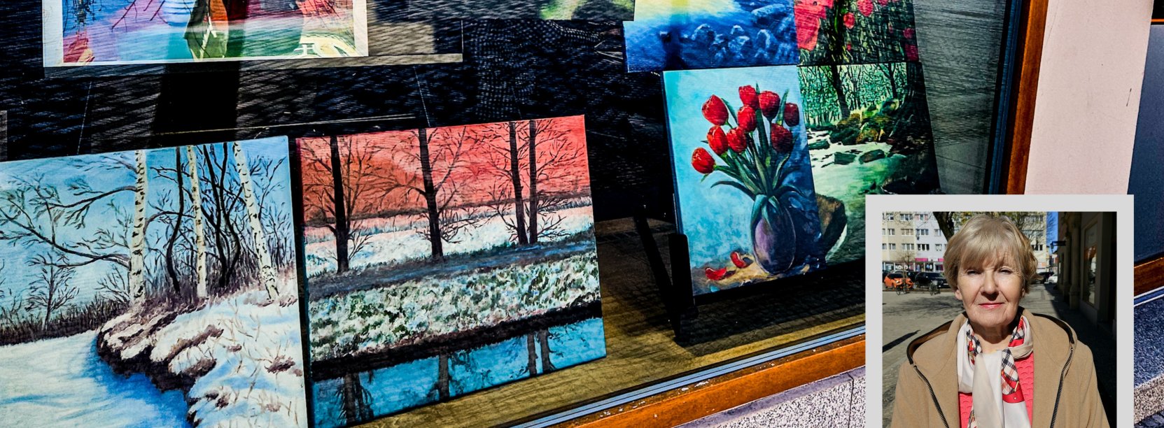 Witryna okienna z pracami malarskimi i zdjęciem autorki