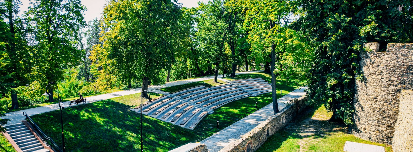 Kamienne mury obronne, amfiteatr chodniki i dużo zieleni - widok z góry.