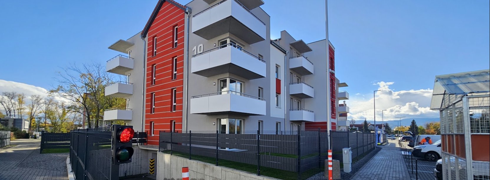 Czteropiętrowy udynek TBS-u, z dużymi balkonami i ogrodzeniem wokół