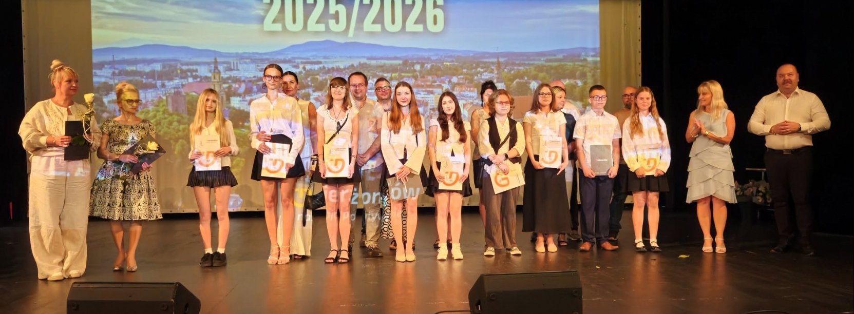 Kilkunastu uczniów z dyplomami na scenie