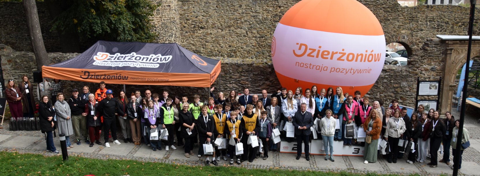 Uczestnicy i organizatorzy 2. edycji gry terenowej „Przedsiębiorczy Dzierżoniów” na tle murów obronnych miasta.