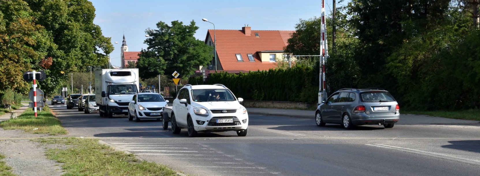 Auta jadące przez przejazd kolejowy