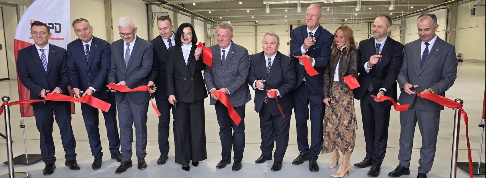 11 osób przecina wstęgę na otwarciu nowej hali produkcyjnej IPD w Dzierżoniowie