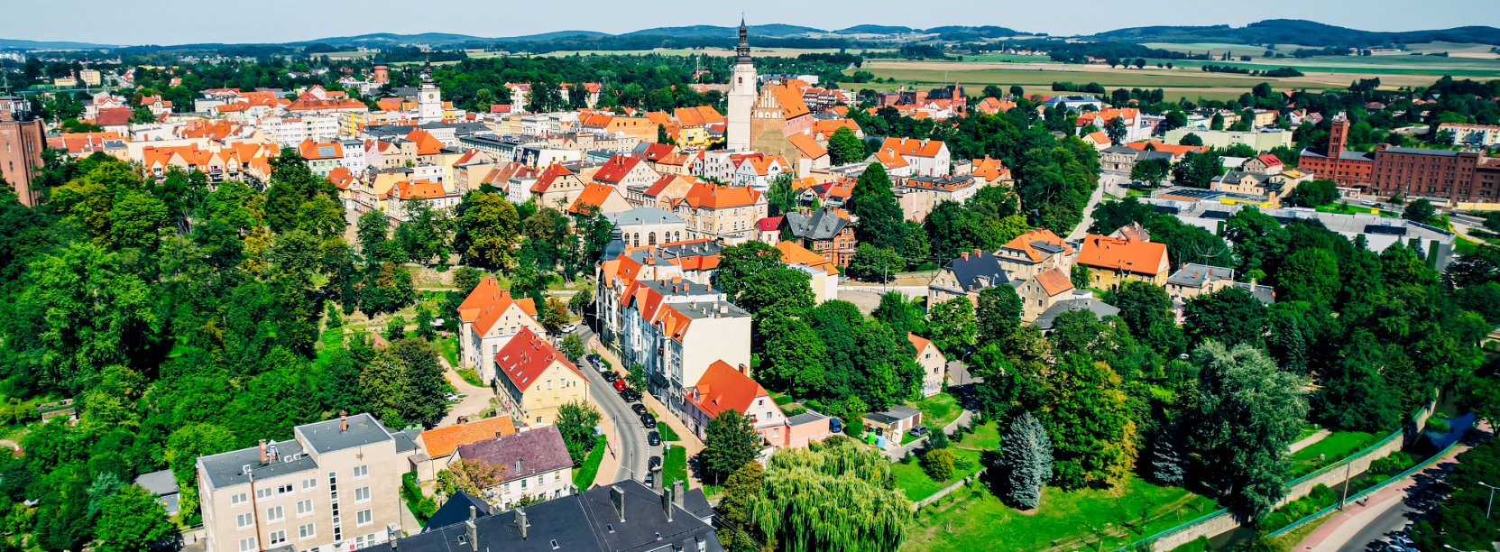 Fragment Dzierżoniowa z lotu ptaka w tle góry