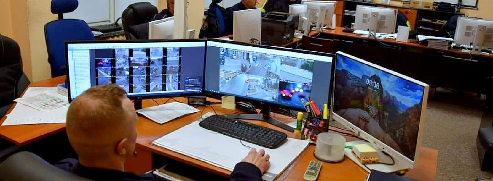straznicy miejscy przed monitorami z monitoringu miejskiego
