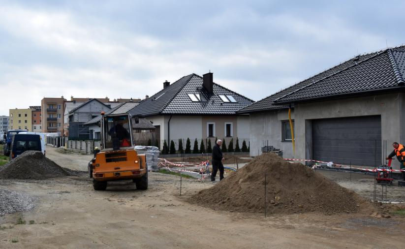 Droga w trakcie budowy, w drugim tle domki jenorodzinne