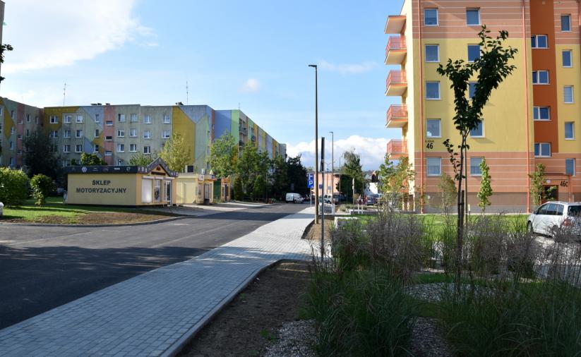Wyremontowany chodnik, z boku zieleń i blok mieszkalny