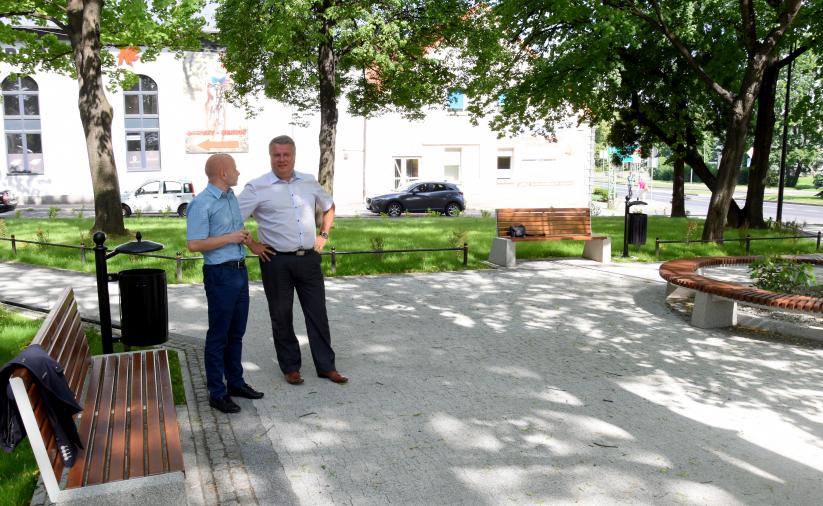 Dwie osoby stojące koło ławki