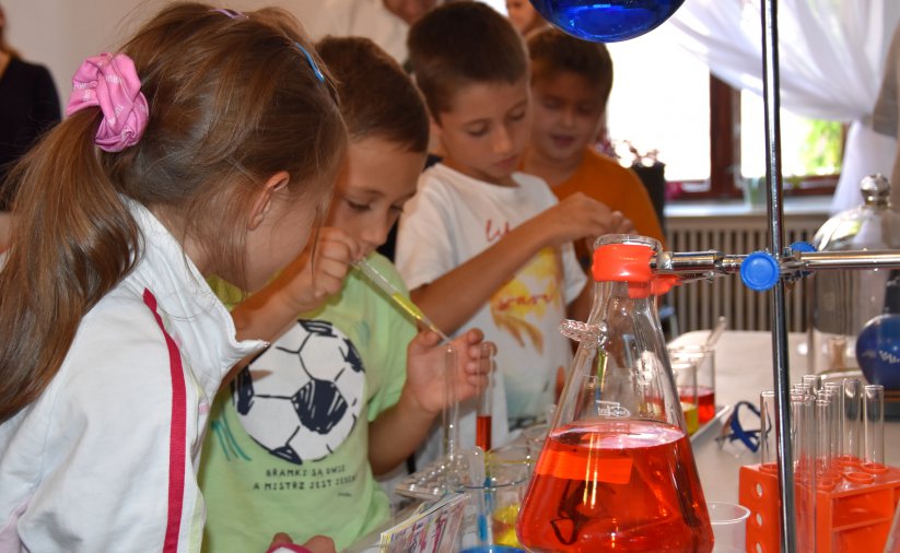 Dzieci przeprowadzające eksperyment chemiczny, na stole fiolki labolatoryjne