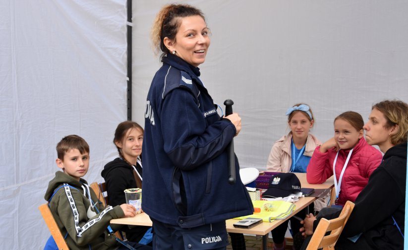 Usmiechnięta policjantka, w tle dzieci