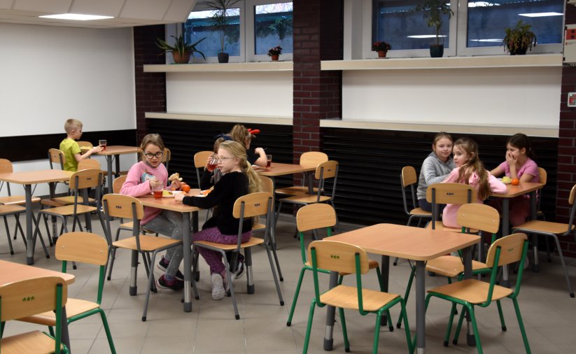 Dzieci jedzące posiłek przy stołach