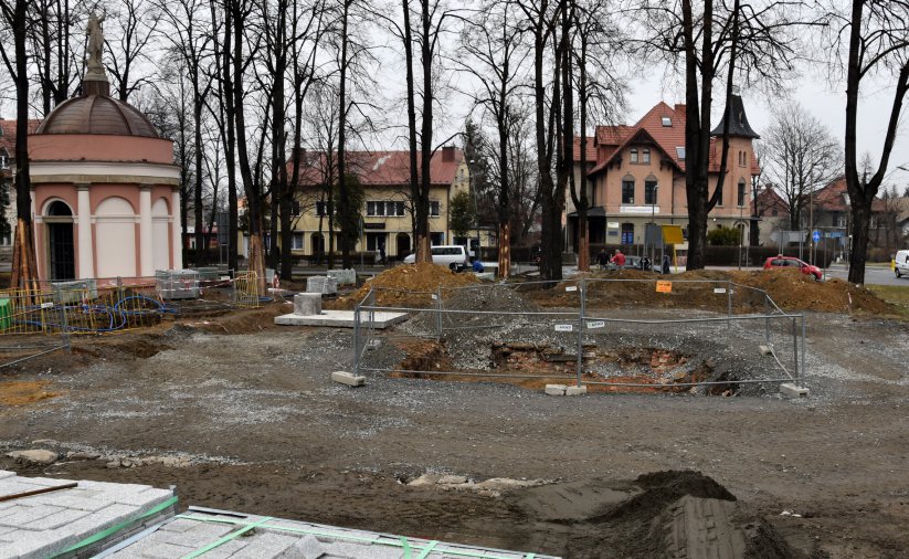 Park w trakcie rewitalizaji, w drugim planie kapliczka