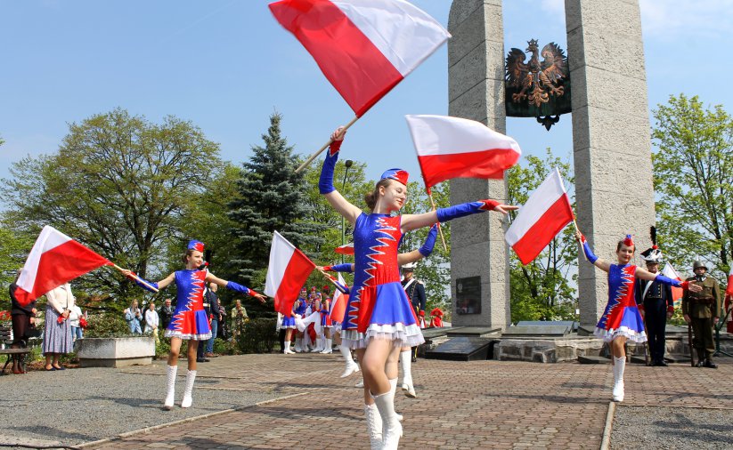 Program artystyczny, mażoretki z flagami Polski przed Pomnikiem Pamięci Losów Ojczyzny