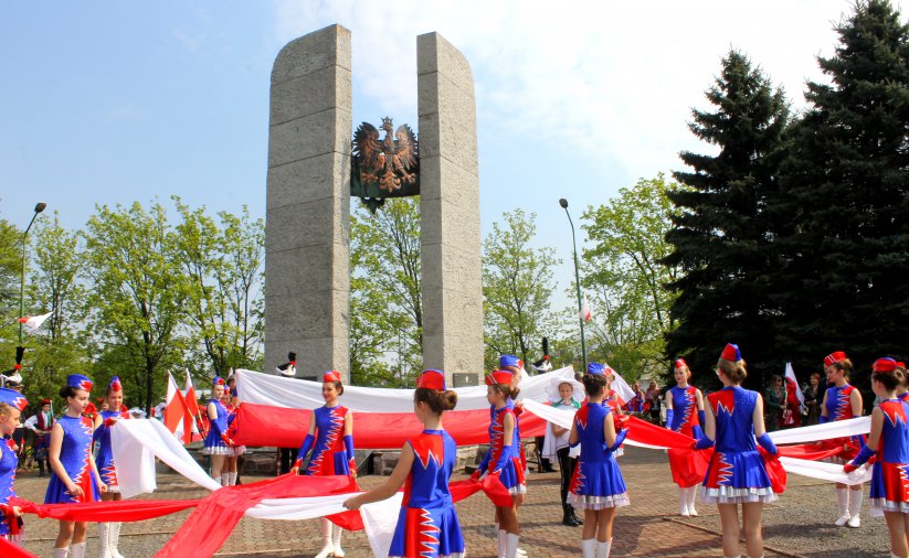 Program artystyczny, mażoretki z flagami Polski przed Pomnikiem Pamięci Losów Ojczyzny