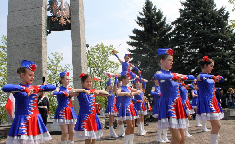 Program artystyczny, mażoretki z flagami Polski przed Pomnikiem Pamięci Losów Ojczyzny