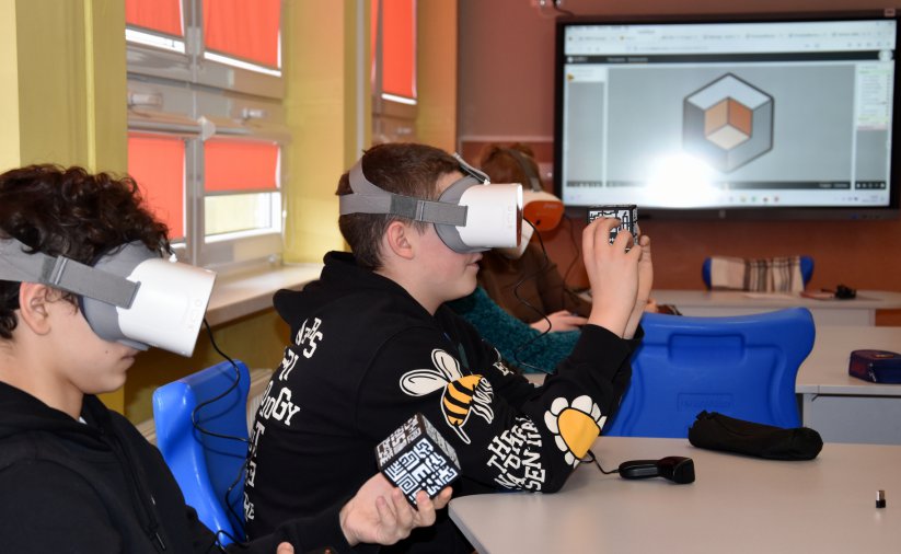 Klasa z tablica interaktywną, uczniowie w okularach VR