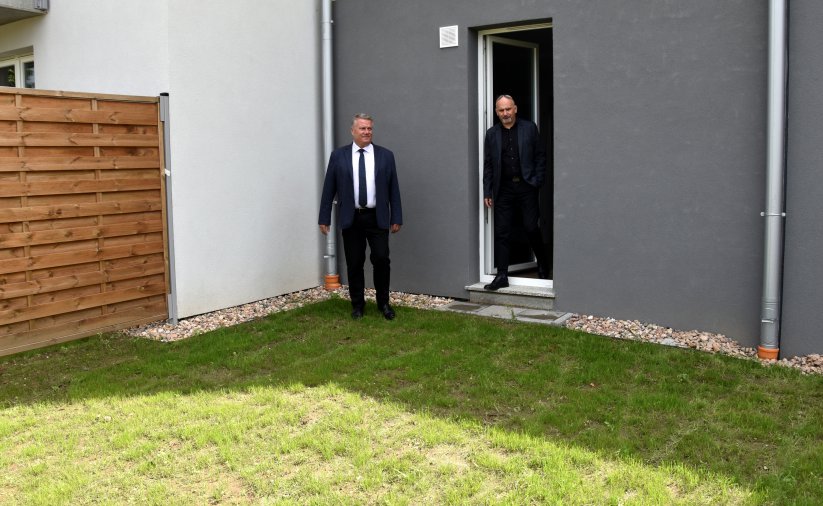 Dwóch mężczyzn stojących przy przydomowym ogródku