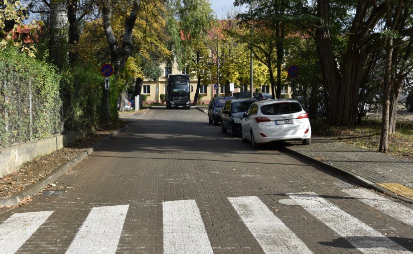 Droga, przejście dla pieszych, po prawej stronie zaparkowane auta