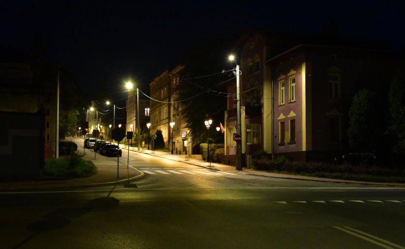 Oświetlona latarniami ulicznymi jezdnia drogi