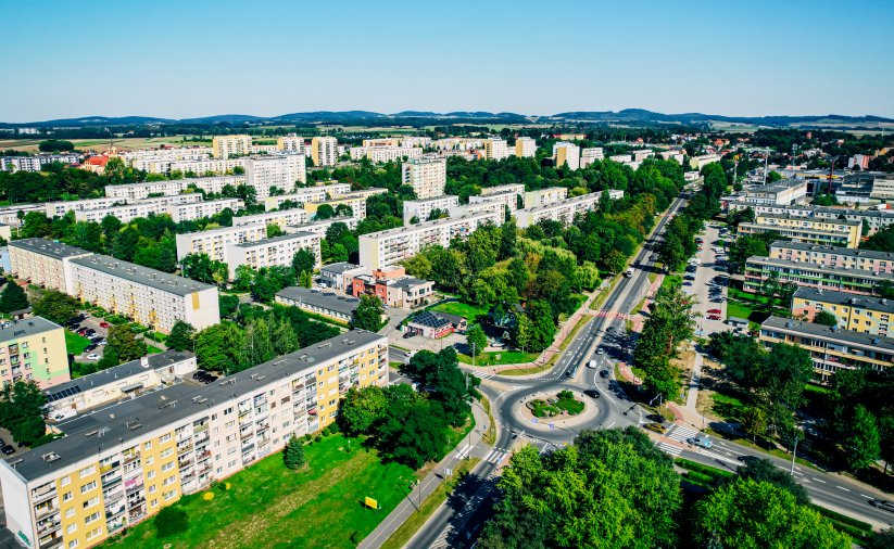 Osiedla mieszkaniowe z góry, po prawej droga z dużym rondem