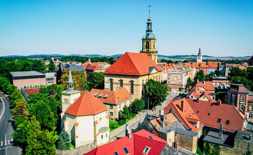 Budynek ościoła i kaplicy z czerwonymi dachami i strzlistą wieżą