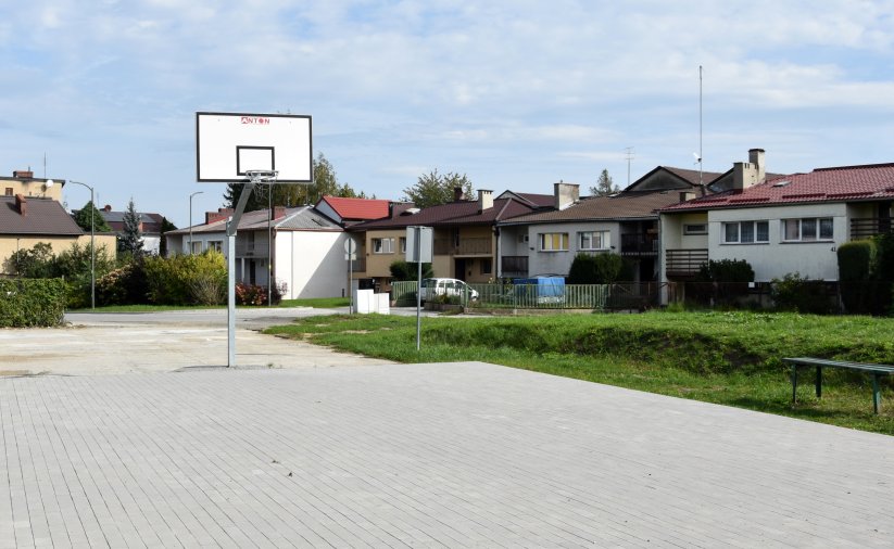 Boisko do koszykówki, w tle domki jednorodzinne