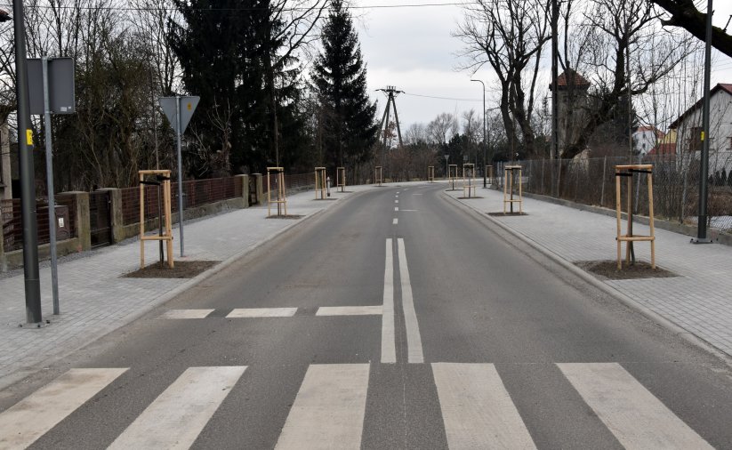 Przejście dla pieszych na nowej drodze, po bokach chodniki z kostki betonowej