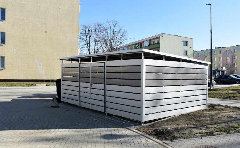 Duży boks na kubły na śmieci obo bloku mieszkalnego
