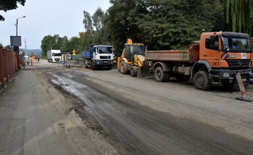 Samochody ciężarowe i maszyny budowlane na remontowanej drodze