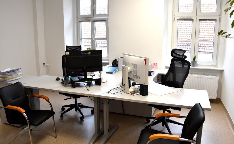 Biuro z dwoma oknami, białe ściany 