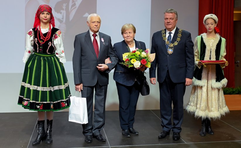 Para jubilatów z burmistrzem, po bokach dwie dziewczyny w strojach ludowych