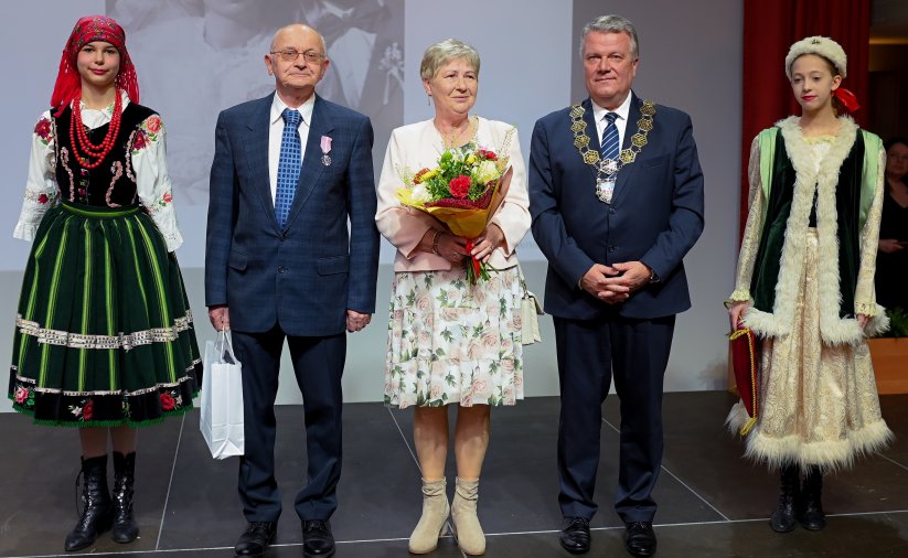 Para jubilatów z burmistrzem, po bokach dwie dziewczyny w strojach ludowych