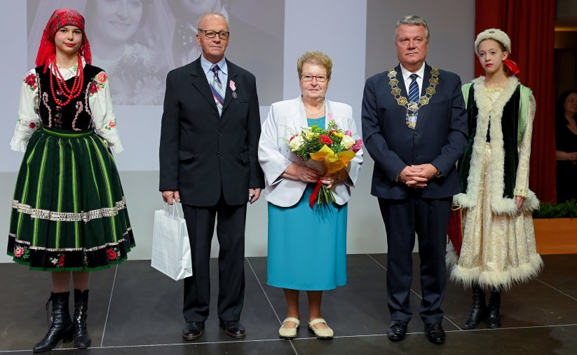 Para jubilatów z burmistrzem, po bokach dwie dziewczyny w strojach ludowych