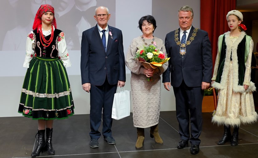 Para jubilatów z burmistrzem, po bokach dwie dziewczyny w strojach ludowych